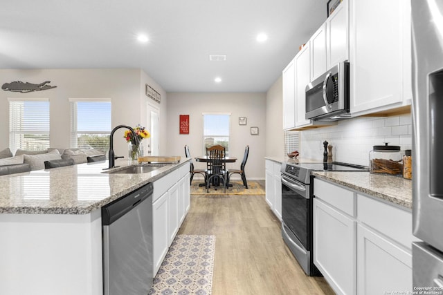 700 Ridge Vw, Seguin, TX 78155 - kitchen featuring appliances with stainless steel finishes, a sink, light wood finished floors, white cabinetry, and recessed lighting