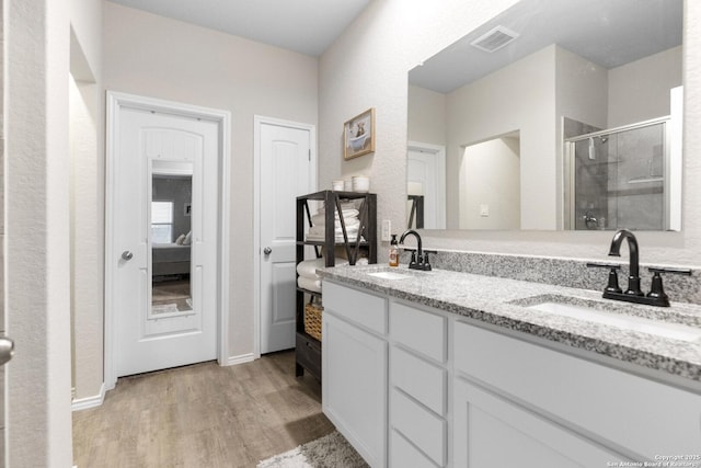 700 Ridge Vw, Seguin, TX 78155 - ensuite bathroom with a stall shower, wood finished floors, and double vanity
