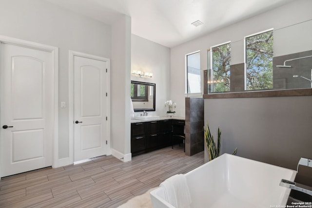 17706 Wild Basin, San Antonio, TX 78258 - bathroom featuring a walk in shower, a freestanding tub, wood finished floors, and vanity