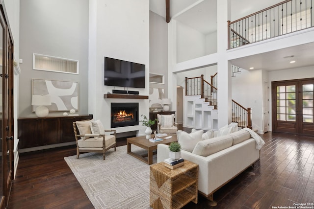 17706 Wild Basin, San Antonio, TX 78258 - living area with a high ceiling, stairway, dark wood finished floors, a warm lit fireplace, and french doors