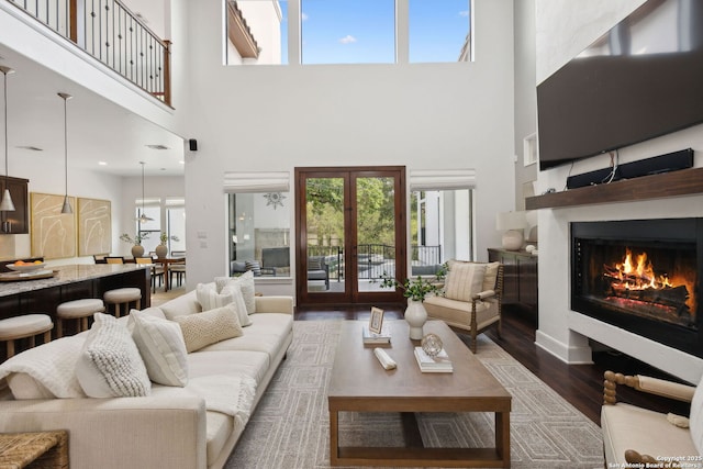 17706 Wild Basin, San Antonio, TX 78258 - living area featuring wood finished floors, a lit fireplace, a towering ceiling, and french doors