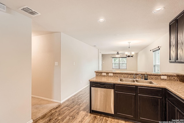 10110 Raspberry Oak, San Antonio, TX 78223 - kitchen with stainless steel dishwasher, a sink, light wood-type flooring, a peninsula, and a chandelier