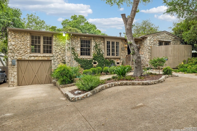 113 E Sunset, San Antonio, TX 78209 - view of front of home featuring stone siding, driveway, and an attached garage