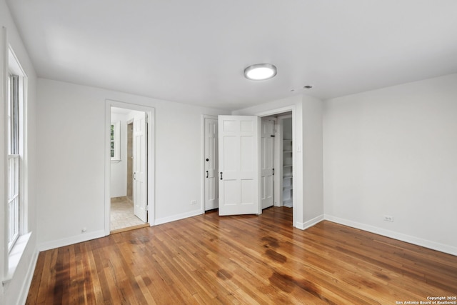 113 E Sunset, San Antonio, TX 78209 - unfurnished bedroom with baseboards, light wood-type flooring, and ensuite bath