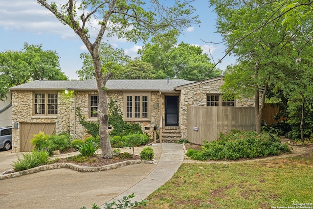 113 E Sunset, San Antonio, TX 78209 - view of front of property featuring stone siding, a shingled roof, and driveway