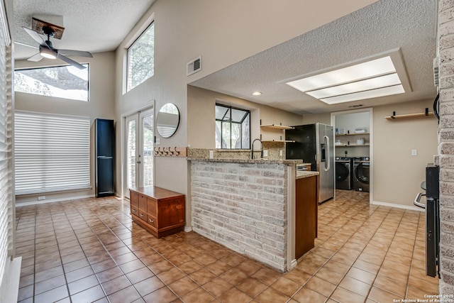13426 Marceline, San Antonio, TX 78232 - kitchen with washing machine and clothes dryer, a textured ceiling, stainless steel refrigerator with ice dispenser, a peninsula, and ceiling fan