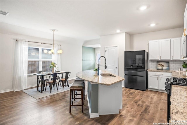 9702 Tupelo Holw, San Antonio, TX 78254 - kitchen featuring black appliances, a sink, white cabinets, light stone counters, and backsplash