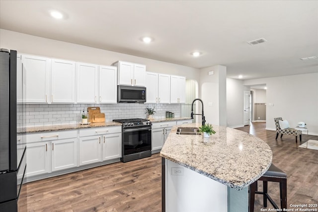 9702 Tupelo Holw, San Antonio, TX 78254 - kitchen featuring stainless steel appliances, a sink, a kitchen bar, backsplash, and a center island with sink