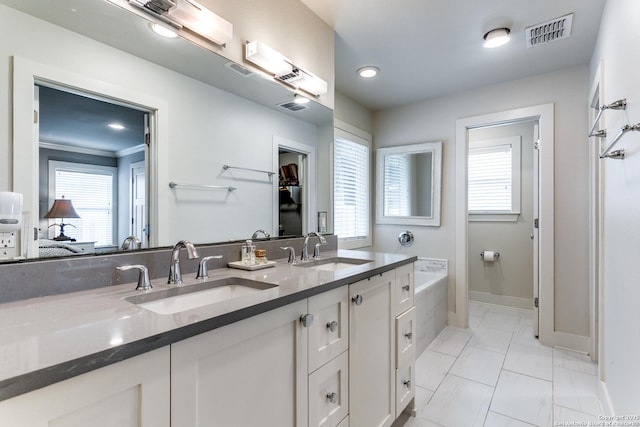 247 Brightwood Pl, San Antonio, TX 78209 - bathroom featuring baseboards, marble finish flooring, double vanity, a tub, and recessed lighting