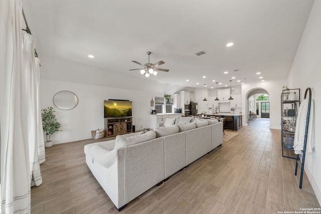9102 War Wagon, San Antonio, TX 78254 - living room with arched walkways, ceiling fan, light wood-type flooring, baseboards, and recessed lighting