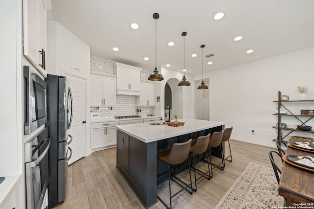 9102 War Wagon, San Antonio, TX 78254 - kitchen with a sink, appliances with stainless steel finishes, light wood-style flooring, white cabinetry, and decorative backsplash