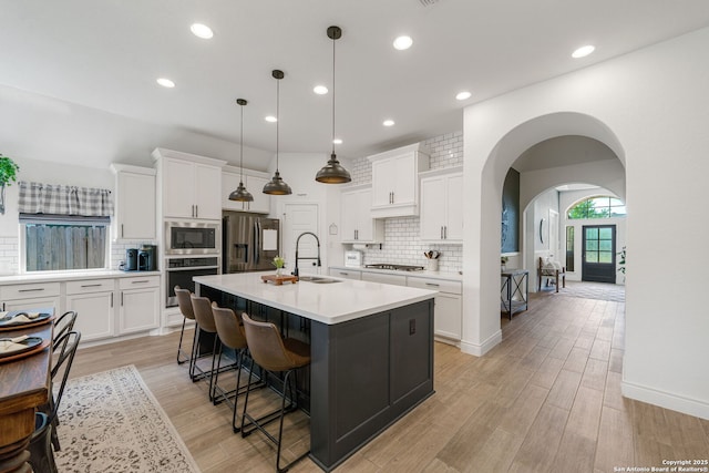 9102 War Wagon, San Antonio, TX 78254 - kitchen with stainless steel appliances, a sink, backsplash, arched walkways, and white cabinets