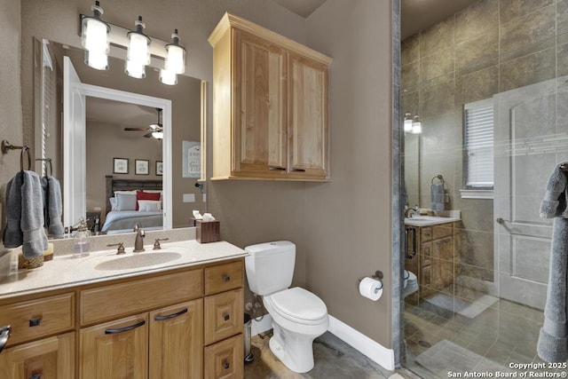 835 Shady Holw, New Braunfels, TX 78132 - ensuite bathroom featuring a stall shower, toilet, vanity, ceiling fan, and baseboards