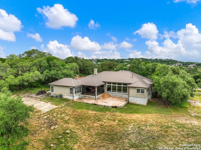 835 Shady Holw, New Braunfels, TX 78132 - back of property with a patio area, a chimney, metal roof, and a forest view