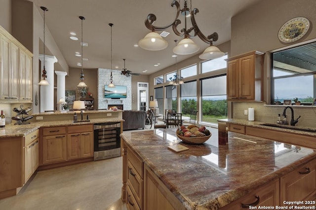 835 Shady Holw, New Braunfels, TX 78132 - kitchen featuring beverage cooler, a sink, decorative backsplash, open floor plan, and a fireplace