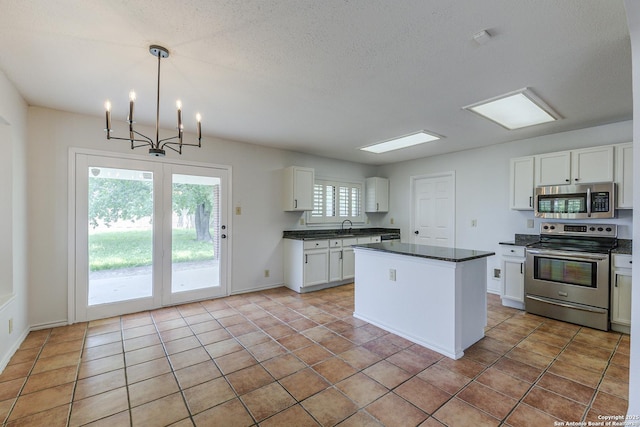 6355 Regency Wood, San Antonio, TX 78249 - kitchen with stainless steel appliances, dark countertops, white cabinets, a center island, and a sink