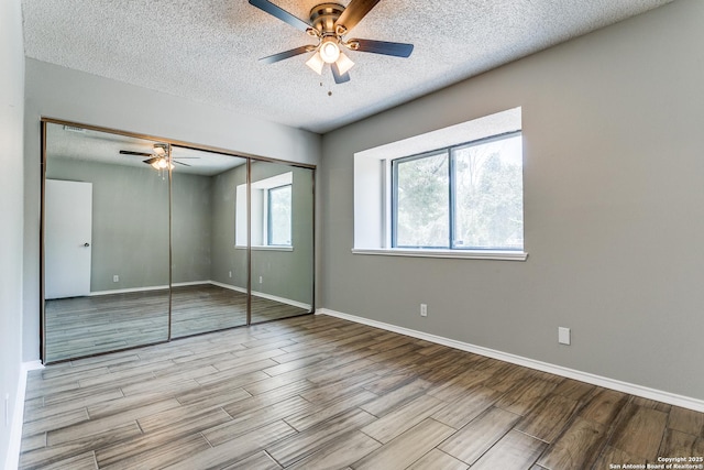 13603 Cobble Way, San Antonio, TX 78231 - unfurnished bedroom with wood finished floors, a textured ceiling, a closet, baseboards, and a ceiling fan