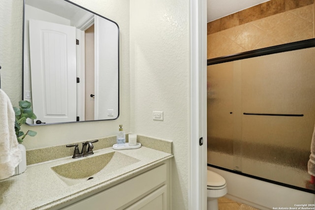 28534 Tristant Rdg, San Antonio, TX 78260 - full bathroom with vanity, a textured wall, toilet, combined bath / shower with glass door, and tile patterned flooring