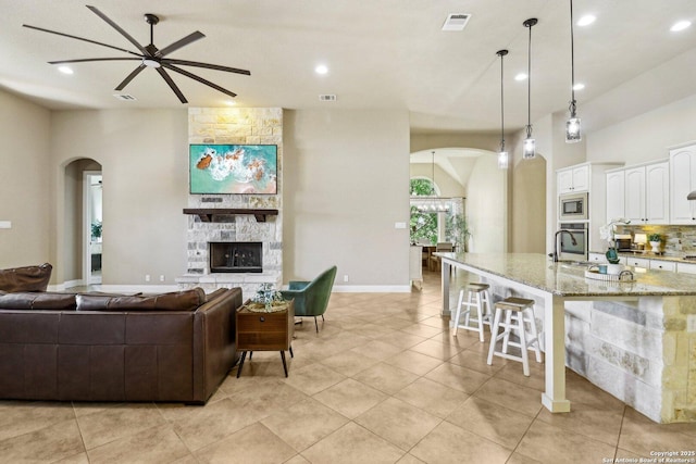 28534 Tristant Rdg, San Antonio, TX 78260 - living room featuring ceiling fan, arched walkways, recessed lighting, a fireplace, and light tile patterned floors