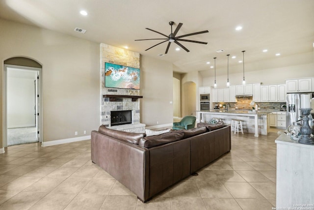 28534 Tristant Rdg, San Antonio, TX 78260 - living room with ceiling fan, arched walkways, light tile patterned floors, recessed lighting, and a stone fireplace