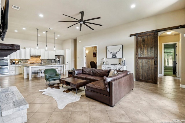 28534 Tristant Rdg, San Antonio, TX 78260 - living room featuring a ceiling fan, light tile patterned floors, a barn door, recessed lighting, and arched walkways