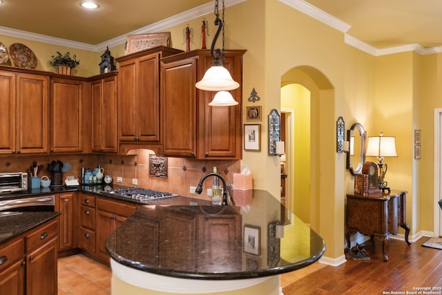 126 Calais Way, Shavano Park, TX 78249 - kitchen featuring a peninsula, arched walkways, dark stone countertops, backsplash, and ornamental molding