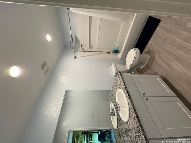 112 Agave Cir, Jourdanton, TX 78026 - bathroom with toilet and wood finished floors