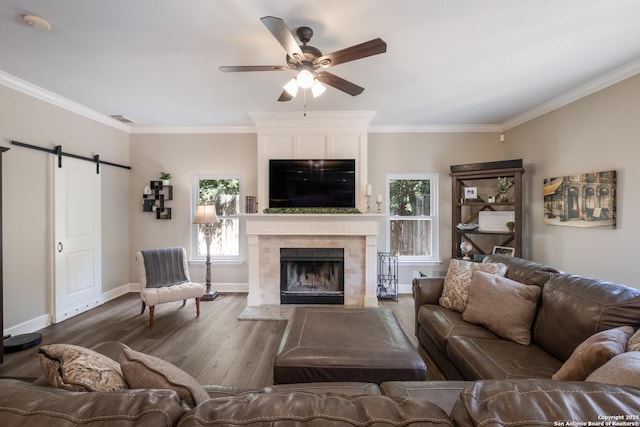 13314 Galicia, Universal City, TX 78148 - living room with ceiling fan, a barn door, wood finished floors, crown molding, and baseboards