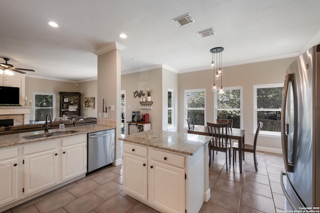 13314 Galicia, Universal City, TX 78148 - kitchen featuring appliances with stainless steel finishes, a sink, open floor plan, a ceiling fan, and ornamental molding