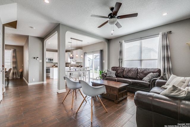 7719 Proton Smt, San Antonio, TX 78252 - living area with ceiling fan, dark wood-type flooring, healthy amount of natural light, a textured ceiling, and baseboards