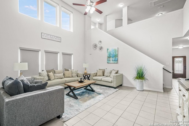 7526 Boxing Elm, San Antonio, TX 78244 - living room featuring a ceiling fan, a high ceiling, light tile patterned flooring, stairway, and baseboards