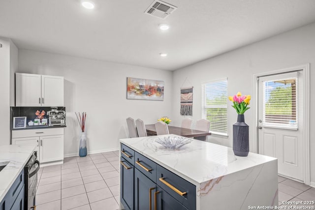 7526 Boxing Elm, San Antonio, TX 78244 - kitchen with light tile patterned floors, white cabinets, light stone countertops, a center island, and recessed lighting