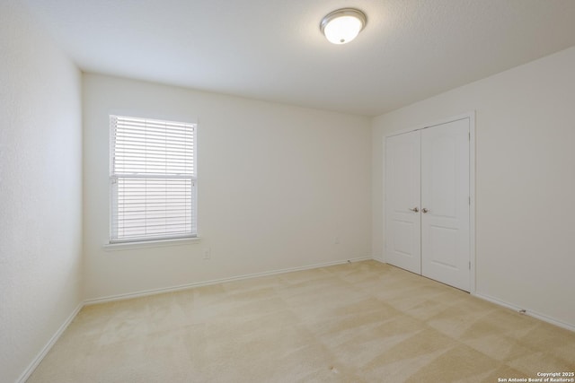 6015 Wisteria Hl, San Antonio, TX 78218 - unfurnished bedroom featuring light colored carpet, a closet, and baseboards