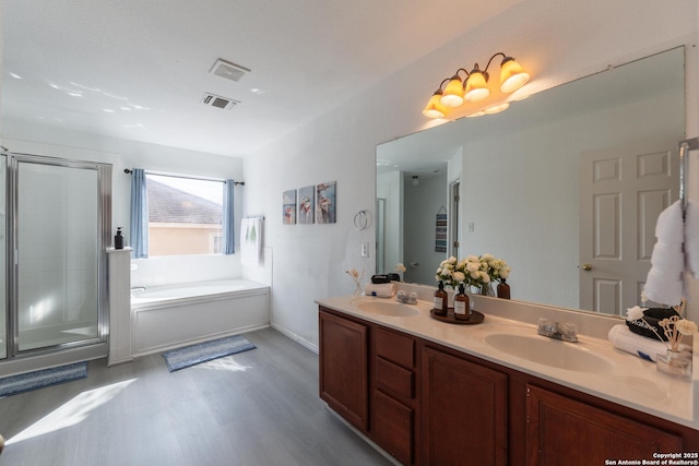 10819 Indigo, San Antonio, TX 78239 - bathroom with a garden tub, wood finished floors, a stall shower, and double vanity