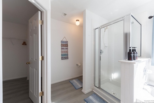 10819 Indigo, San Antonio, TX 78239 - bathroom with a stall shower, wood finished floors, a spacious closet, and baseboards