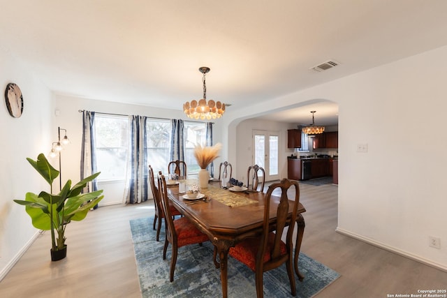 10819 Indigo, San Antonio, TX 78239 - dining space featuring arched walkways, a chandelier, light wood finished floors, and baseboards