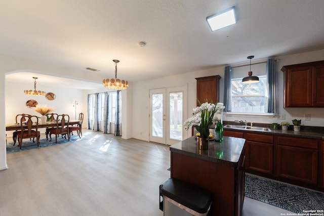 10819 Indigo, San Antonio, TX 78239 - kitchen featuring dark countertops, a sink, a chandelier, and light wood-style floors