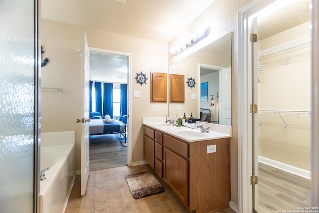 11610 Lemonmint, San Antonio, TX 78245 - full bathroom featuring ensuite bathroom, double vanity, a tub to relax in, and baseboards