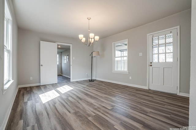 2411 W Huisache Ave, San Antonio, TX 78228 - unfurnished dining area with healthy amount of natural light, dark wood-style floors, a chandelier, and baseboards