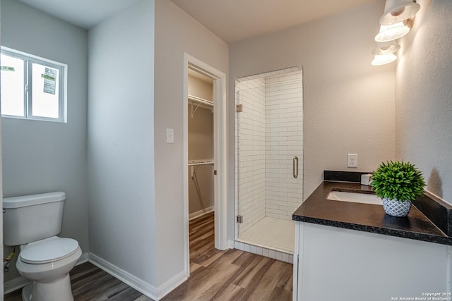 2411 W Huisache Ave, San Antonio, TX 78228 - full bathroom with wood finished floors, a shower stall, toilet, a spacious closet, and vanity