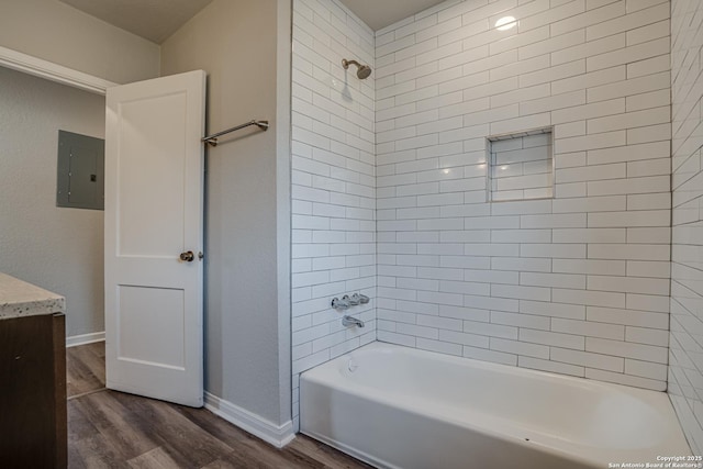 2411 W Huisache Ave, San Antonio, TX 78228 - bathroom featuring electric panel, wood finished floors, bathtub / shower combination, vanity, and baseboards