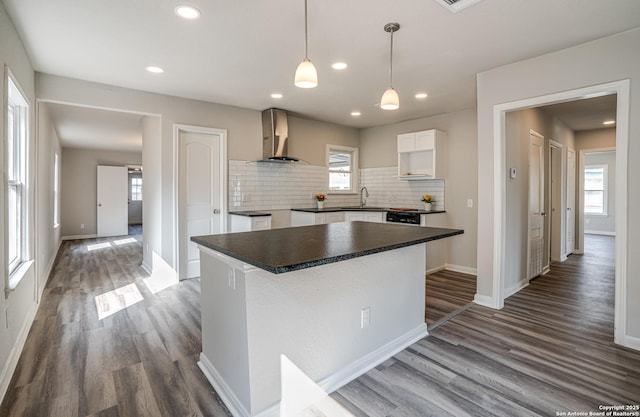 2411 W Huisache Ave, San Antonio, TX 78228 - kitchen with wall chimney range hood, dark countertops, decorative backsplash, dark wood finished floors, and baseboards