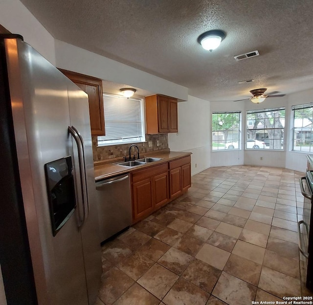 3730 Candlestone, San Antonio, TX 78244 - kitchen with appliances with stainless steel finishes, a sink, a textured ceiling, decorative backsplash, and ceiling fan