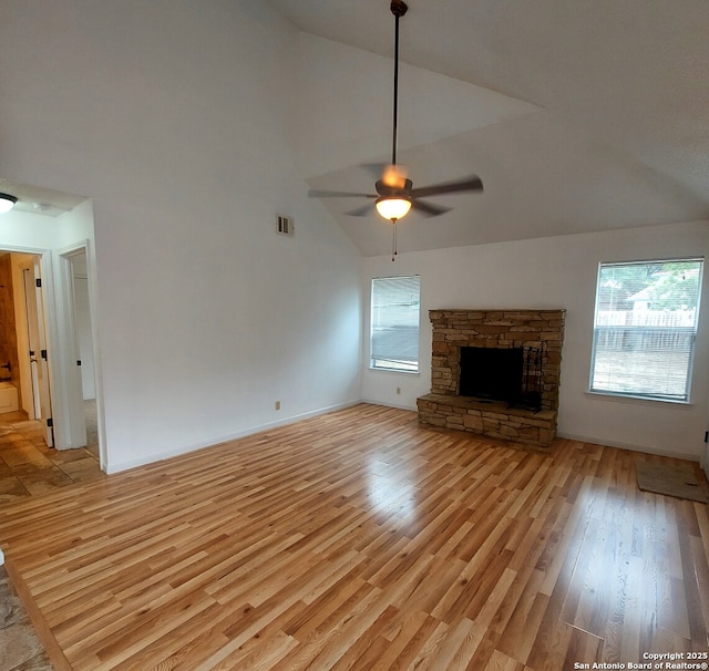 3730 Candlestone, San Antonio, TX 78244 - unfurnished living room with high vaulted ceiling, light wood-style flooring, ceiling fan, a stone fireplace, and baseboards