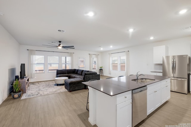 5957 Cerulean, Bulverde, TX 78163 - kitchen with appliances with stainless steel finishes, a sink, light wood finished floors, a ceiling fan, and white cabinets