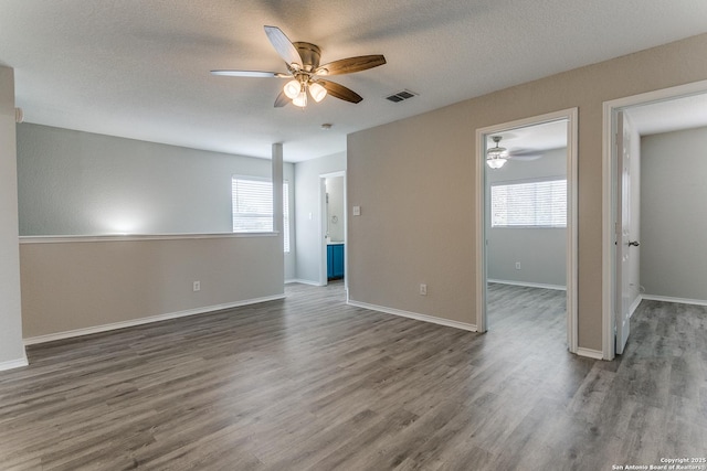 16311 Kentucky Rdg, Selma, TX 78154 - empty room featuring a ceiling fan, plenty of natural light, wood finished floors, and a textured ceiling