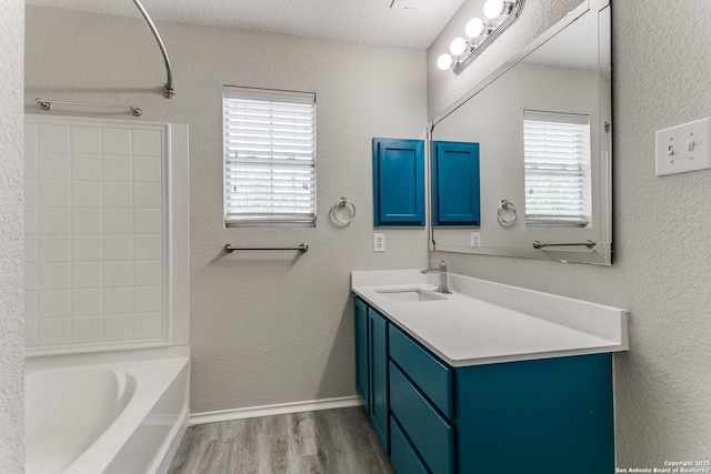 16311 Kentucky Rdg, Selma, TX 78154 - full bathroom featuring plenty of natural light, wood finished floors, vanity,  shower combination, and a textured wall