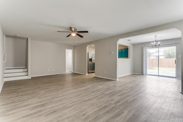 16311 Kentucky Rdg, Selma, TX 78154 - unfurnished living room with ceiling fan, wood finished floors, a chandelier, arched walkways, and baseboards