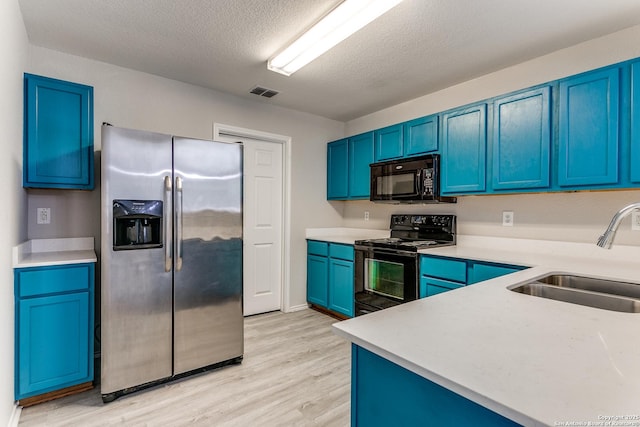 16311 Kentucky Rdg, Selma, TX 78154 - kitchen with black appliances, a sink, blue cabinets, light wood-style floors, and light countertops