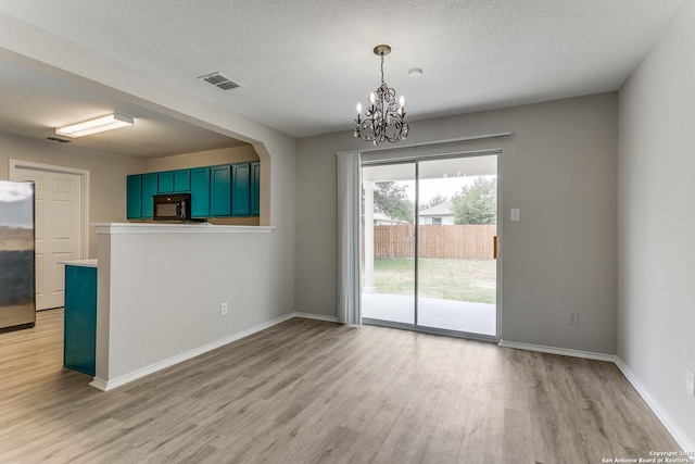 16311 Kentucky Rdg, Selma, TX 78154 - unfurnished dining area featuring light wood finished floors, a chandelier, baseboards, and a textured ceiling